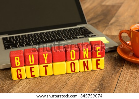 Buy One Get One written on a wooden cube in a office desk Royalty-Free Stock Photo #345759074