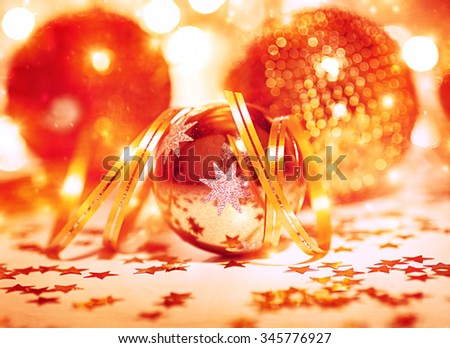 Festive Christmas still life, beautiful golden shiny decorative balls with ribbon and little stars on the table, traditional winter holidays decor
