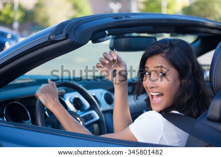 Closeup portrait, young cheerful, joyful, smiling, gorgeous woman holding up keys to her first new sports car. Customer satisfaction Royalty-Free Stock Photo #345801482