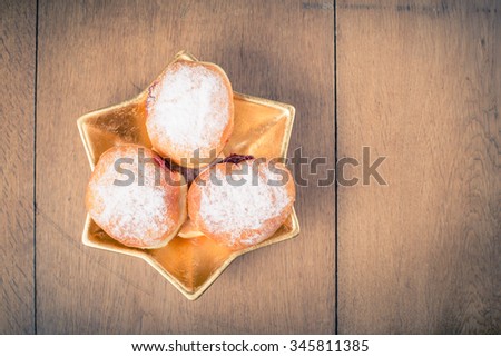 Hanukkah jelly donuts on David star shaped plate. Retro style filtered photo