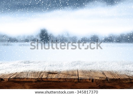 xmas winter blurred background in blue color and shabby wooden table place 