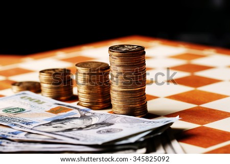 Tower coins and dollars on a chessboard, money
