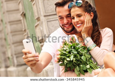 A picture of a young romantic couple using smartphone in the city
