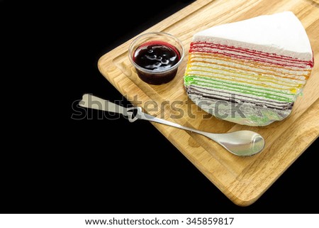 Crepe rainbow cake and blueberry topping with black background