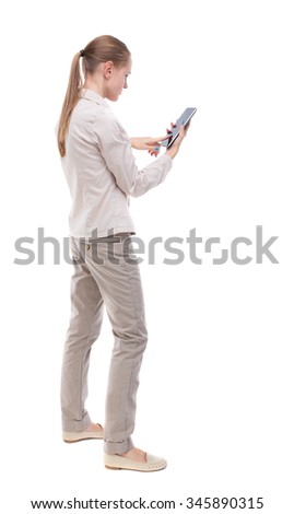 back view of standing young beautiful  woman and using a mobile phone. girl  watching. backside view of person. Isolated over white background. A girl in a white jacket clicks on the screen smartphone