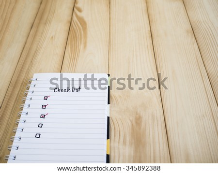 Checklist on notebook page with wood background