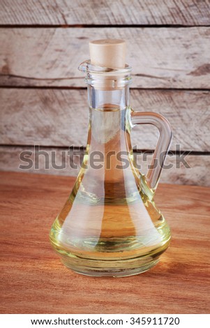 oil in glass jug on wooden background