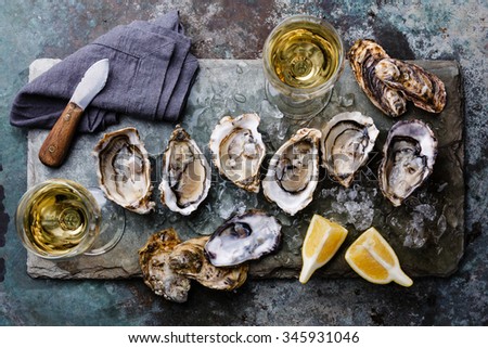 Open Oysters Fines de Claire on stone plate with lemon Royalty-Free Stock Photo #345931046