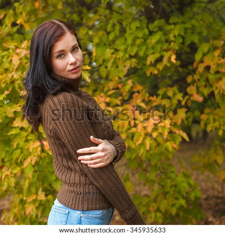 beautiful girl in a brown pullover in autumn park