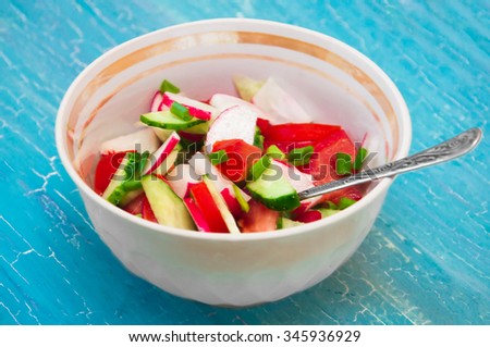 vegetable salad in a white bowl on a blue background