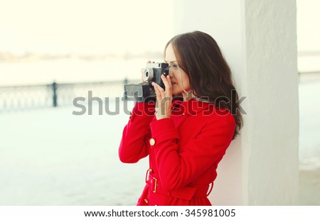Pretty brunette young woman with retro vintage camera in winter day