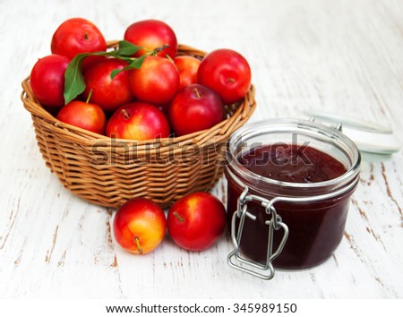 Plum jam and fresh berries on a wooden background