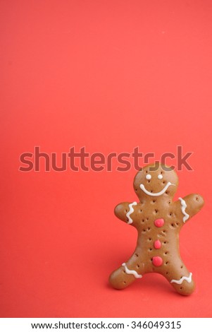 Gingerbread man decorated colored icing. Holiday cookie in shape of man in red background