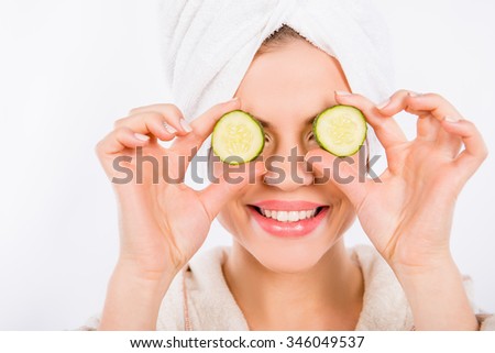 Nice young woman with cucumber, isolated on a white background