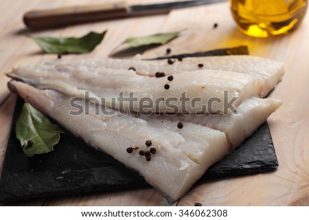 Raw Atlantic halibut fillet on a slate board
