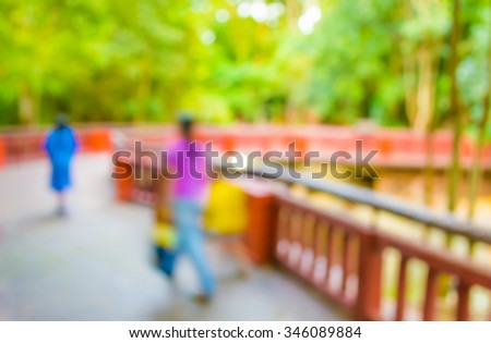 image fo blur people walking at long corridor with open space to green garden for background usage.