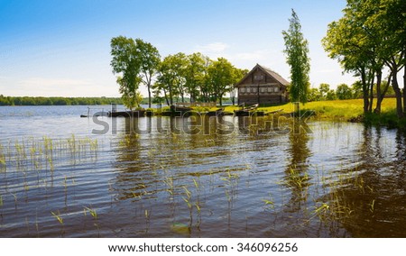 Amazing beautiful rural landscape.  Blue lake Kizhi in Karelia. North country Russia. Green grass and trees in meadow. Azure water. Sunny day. 