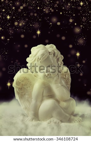 Little white guardian angel on dark background.