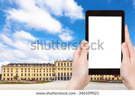 travel concept - tourist take photo of Schloss Schonbrunn palace in Vienna on tablet pc with cut out screen with blank place for advertising logo