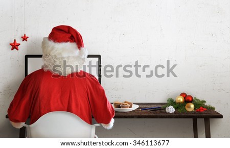 Santa Claus responds to letters on a computer for Christmas