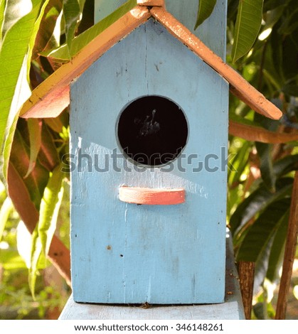 blue wooden bird house in the garden