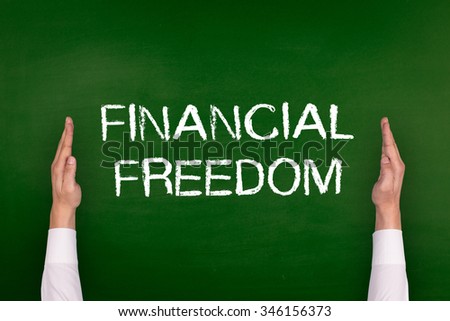 Hands Showing FINANCIAL FREEDOM on Blackboard