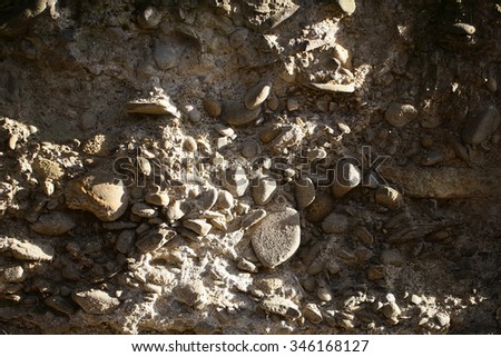 Photo closeup outdoor of sandy old pebble stone wall facade exterior of rocks of various sizes and forms on mural background, horizontal picture