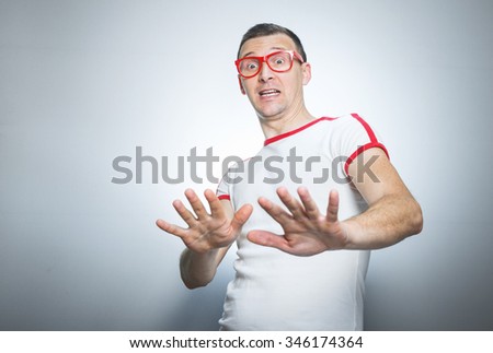 Fearful funny guy showing his palms, stay away from me. 
Don't come closer to me.
Isolated on gray Royalty-Free Stock Photo #346174364