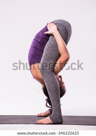 young beautiful yoga woman posing on a studio background