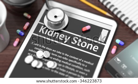 Tablet with "Kidney Stone" on screen, stethoscope, pills and objects on wooden desktop.