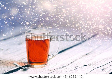 Hot tea at winter in snowfall