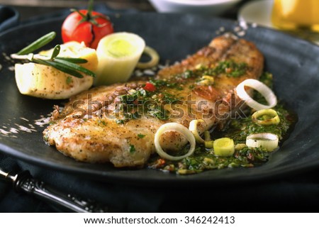 Grilled fish with lemon and rosemary in the sauce