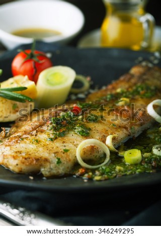 Grilled fish with lemon and rosemary in the sauce