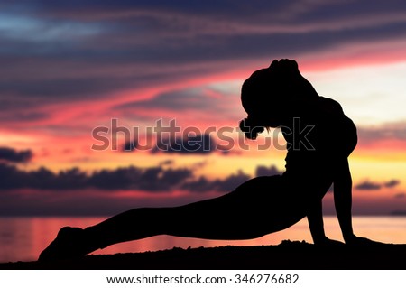 Silhouette one woman with professional yoga posture on the beach at sunset.