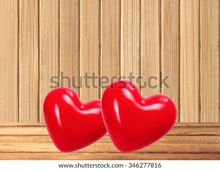Red hearts on wooden table over wooden background
