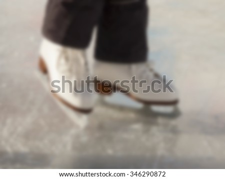 Blurred image of children's feet in skates on ice