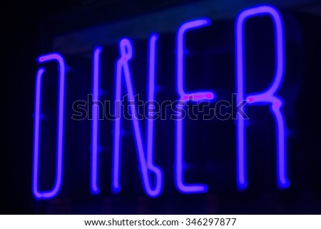 Diner neon sign at night in street photo.