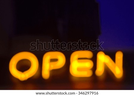 Neon open sign at night in street photo.