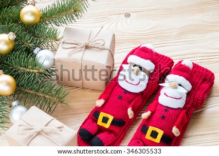 knitted Christmas Stockings as Santa Claus, christmas gifts packaged in kraft paper,  jute rope constricted  on wooden table with Christmas tree . top view, free space for text