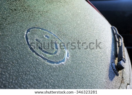 Smiley on window of a car in a frost