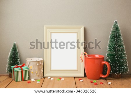 Poster frame mock up template for Christmas holiday greeting presentation with cup and small pine trees