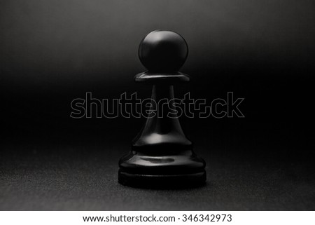 Chess. Black pawn on a black background. Pawn, infantry chess.