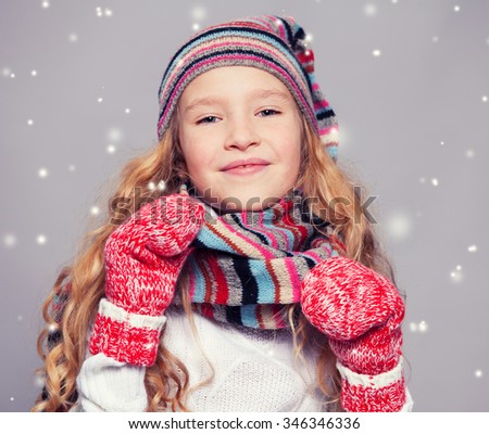Girl in winter clothes. Happy child. Studio shot