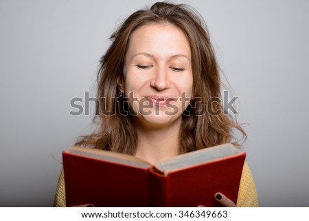 young beautiful girl reading a book, bright picture in a yellow studio shot isolated on gray background