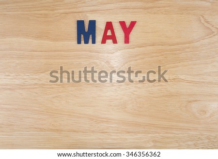 Word spelling month in the year "May" by wooden letters on wood background (Month name word series)