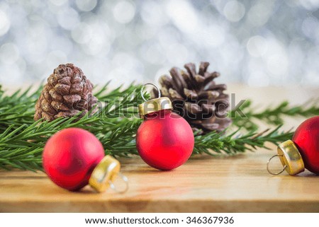 Christmas decoration with fir tree and pine cones on wooden table over abstract bokeh background, selective focus