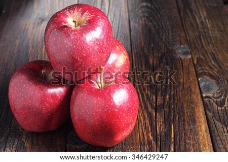 Large red apples on dark wooden table