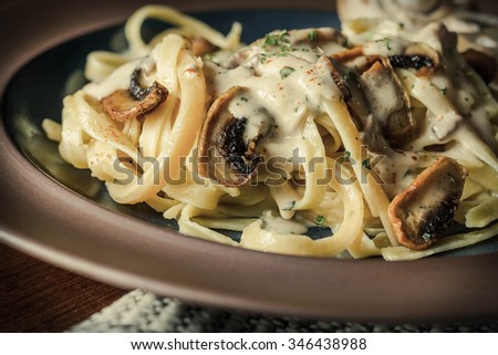 Fancy organic fetuccine pasta with creamy alfredo mushroom sauce Royalty-Free Stock Photo #346438988