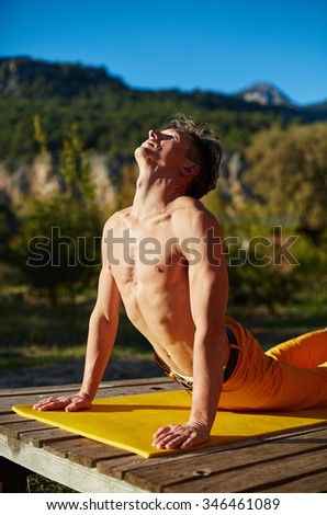young man doing yoga in the early morning on the garden terrace of the house