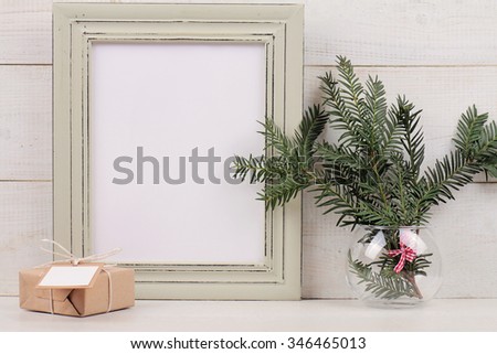 Christmas and New Year background. Empty picture frame, fir branch and vintage gift box with with copy space blank tag on white background. Scandinavian style home interior decoration